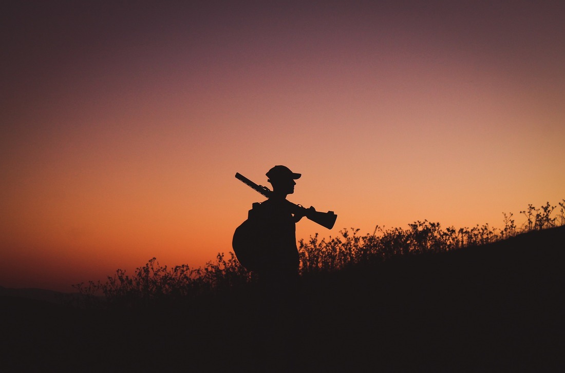Un cazador que porta un arma