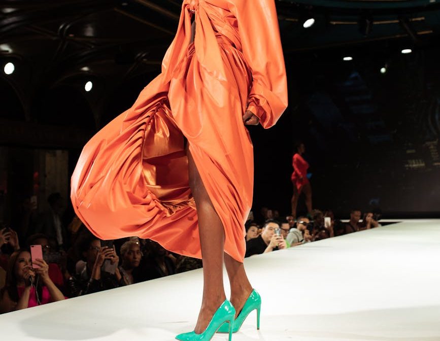 Modelo con un vestido naranja en una pasarela de moda